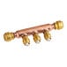 A copper pipe with three SharkBite brass fittings connected to it.