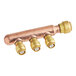 A copper pipe with three brass SharkBite fittings attached to a copper manifold.