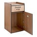 A wooden Lancaster Table & Seating waste receptacle enclosure with a "THANK YOU" swing door.