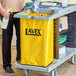 A man holding a yellow Lavex vinyl bag for a cleaning cart.