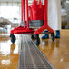 A Vikan red cleaning cart with red cleaning tools including a bucket and mop.