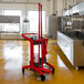 A red Vikan mobile cleaning station with cleaning supplies on it.