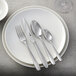 A white plate with a Sola the Netherlands Siena stainless steel salad/dessert fork on it.