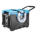 An XPOWER commercial dehumidifier with a drainage hose attached.