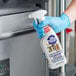 A person in blue gloves using Bar Keepers Friend stainless steel cleaner spray on a stove.