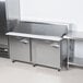 A Traulsen stainless steel sandwich prep table with two left hinged doors.