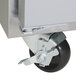 A close-up of a wheel on a stainless steel Traulsen sandwich prep table.