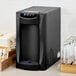 A black Narvon countertop water dispenser with cups on a counter.