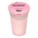 A pink plastic container with a f'real strawberry milkshake and a pink lid.