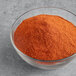 A bowl of McCormick Culinary Paprika on a gray surface.