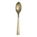 A close up of a Varick Malcolm stainless steel teaspoon with a gold handle.