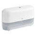 A white plastic Tork toilet paper dispenser with a lid and handle.
