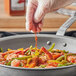 McCormick Culinary Ground Red Pepper being poured onto shrimp in a professional kitchen.