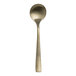 A Varick Malcolm stainless steel bouillon spoon with a gold handle.