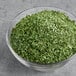 A bowl of McCormick Culinary Parsley Flakes on a table.