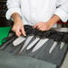 A chef holding a knife in a knife case.