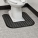 A white toilet with a black Lavex rubber mat on the floor.