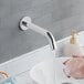 A person washing their hands under a Waterloo wall-mount hands-free sensor faucet.