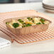 A Solut kraft paperboard tray of food with broccoli and cheese.