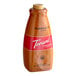 A close up of a Torani Pumpkin Pie flavoring sauce bottle with a red label.