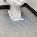 A toilet with a grey Lavex toilet floor mat on it.