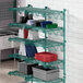 A Regency green wire shelf with containers and dishes on it.