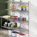 A Regency stainless steel wall-mount shelf with containers on it.