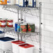 A metal Regency wall-mount shelf with food cans on it.