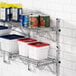 A Regency chrome wall-mount shelf with food containers and cans on it.