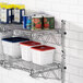 A Regency chrome wall-mount shelf with food containers and cans on it.