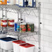 A metal wire shelf with cans of food on it.