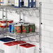 A Regency stainless steel wall-mount shelf with canned food on it.