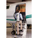 A woman walking up the stairs of an airplane using a ProTeam AviationVac backpack vacuum.