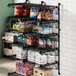 A Regency black wire wall-mount shelf with snacks and boxes on it.