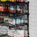 A Regency black wire shelf with food and snacks on it.
