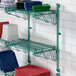 A Regency green wire shelf with dishes on it.