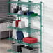 A green Regency wire shelf with dishes and containers on it.
