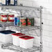 A Regency metal wall-mount shelf with food containers on it.