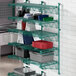 A green metal shelf with different items on it.