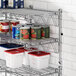 A Regency chrome wire shelf with food cans and containers on it.