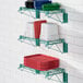 A Regency green epoxy wire shelf with dishes and pots on it.