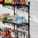 A Regency black wire shelf with food and snacks on it.