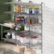 A Regency stainless steel wall-mount shelf post with double brackets holding shelves of food.