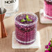 A glass of purple NOROI Esprit-de-London Non-Alcoholic Gin with a sprig of mint on top.