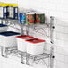 A Regency chrome wall-mounted wire shelf with food containers and cans on it.