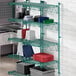 A green metal Regency wire rack with blue trays on it.
