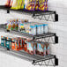 A Regency black wire shelf with food and snacks on it.