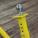 A yellow metal post with a round metal ball on top.