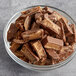 A close up of Gertrude Hawk peanut butter cup slices in a bowl of chocolate.