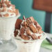 Two dessert cups with chocolate and peanut butter on a table.